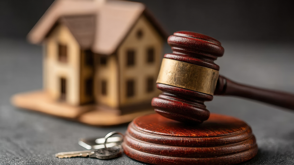 Rent control image of judges gavel in front of model house and keys