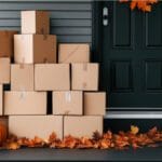Image of moving boxes outside a house with pumpkins and fall leaves