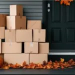 Image of moving boxes outside a house with pumpkins and fall leaves