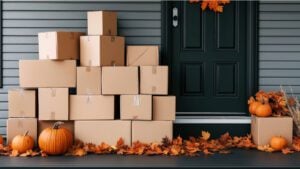 Image of moving boxes outside a house with pumpkins and fall leaves