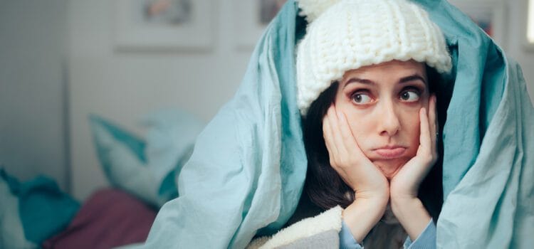 Repair Request Rumble Image of woman bundled up in a comforter and hat due to no heat, repair request