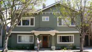 East Bay rental property with clean gutters, spring foliage, and a landlord conducting a seasonal exterior inspection